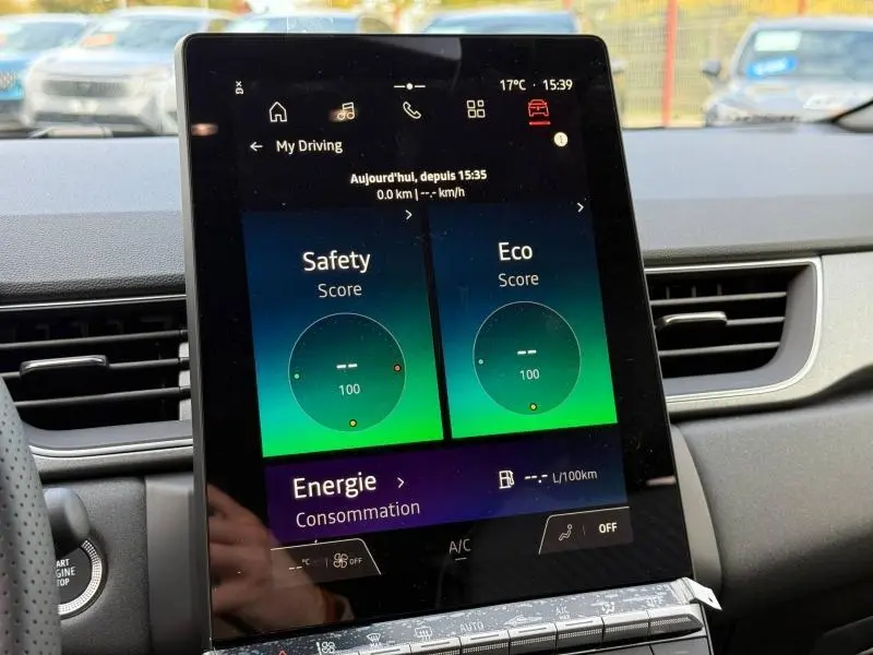 Vue rapprochée de l’écran tactile central du Renault Captur 2025 affichant scores Safety et Eco, intérieur gris.