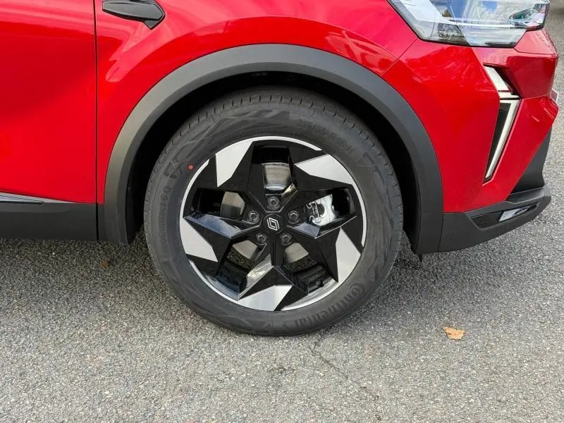 Gros plan sur la roue avant droite du Renault Captur rouge 2025, avec jante alu noire et argentée au design étoilé.