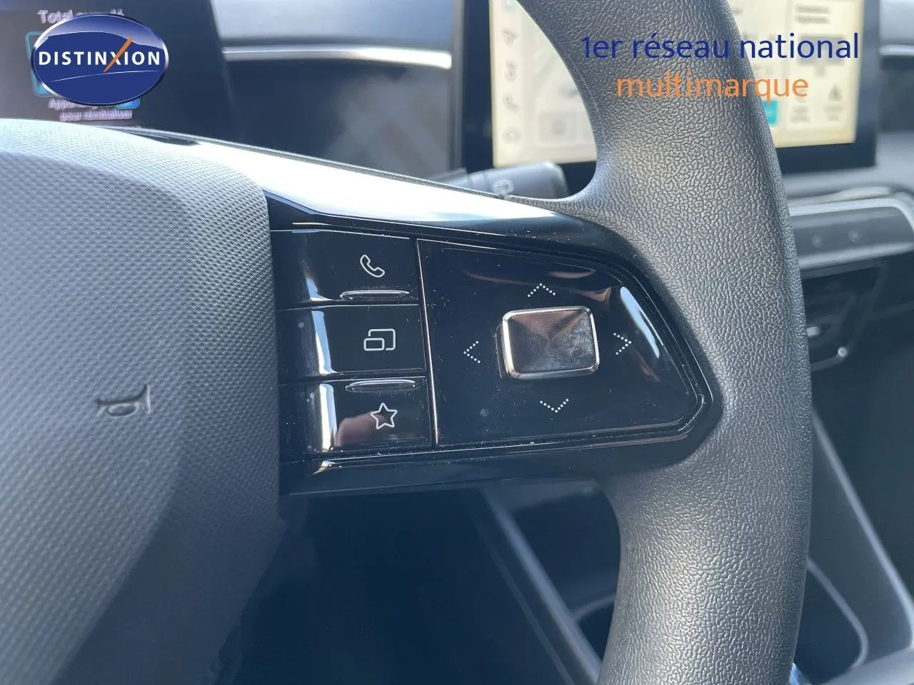 Gros plan sur les commandes gauche du volant du MG3 1.5L Hybrid+ 2024 avec finition noire et tableau de bord en arrière-plan.