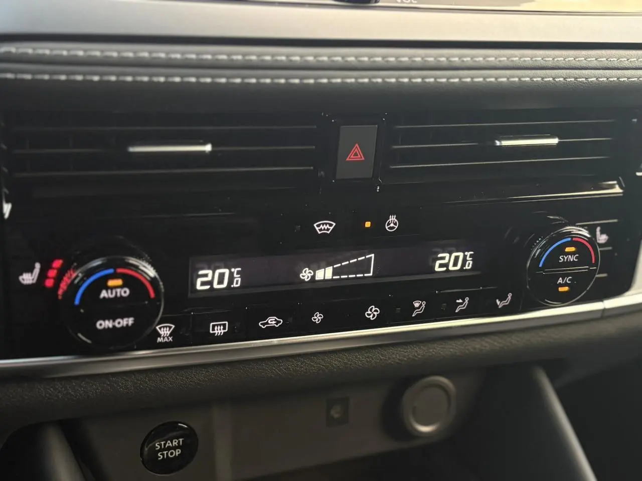 Gros plan sur la console centrale du Nissan Qashqai gris Ceramic, affichant la climatisation automatique bi-zone à 20°C.