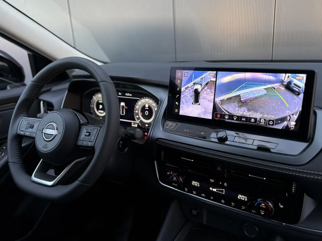 Vue intérieure du tableau de bord et volant du Nissan Qashqai 2025 avec écran tactile affichant la caméra 360° et instrumentation numérique.