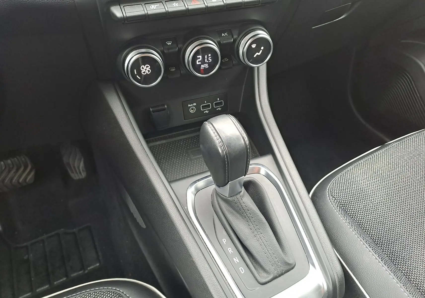 Gros plan sur la console centrale du Renault Captur bleu marine 2022, montrant le levier de boîte auto et les commandes de climatisation.