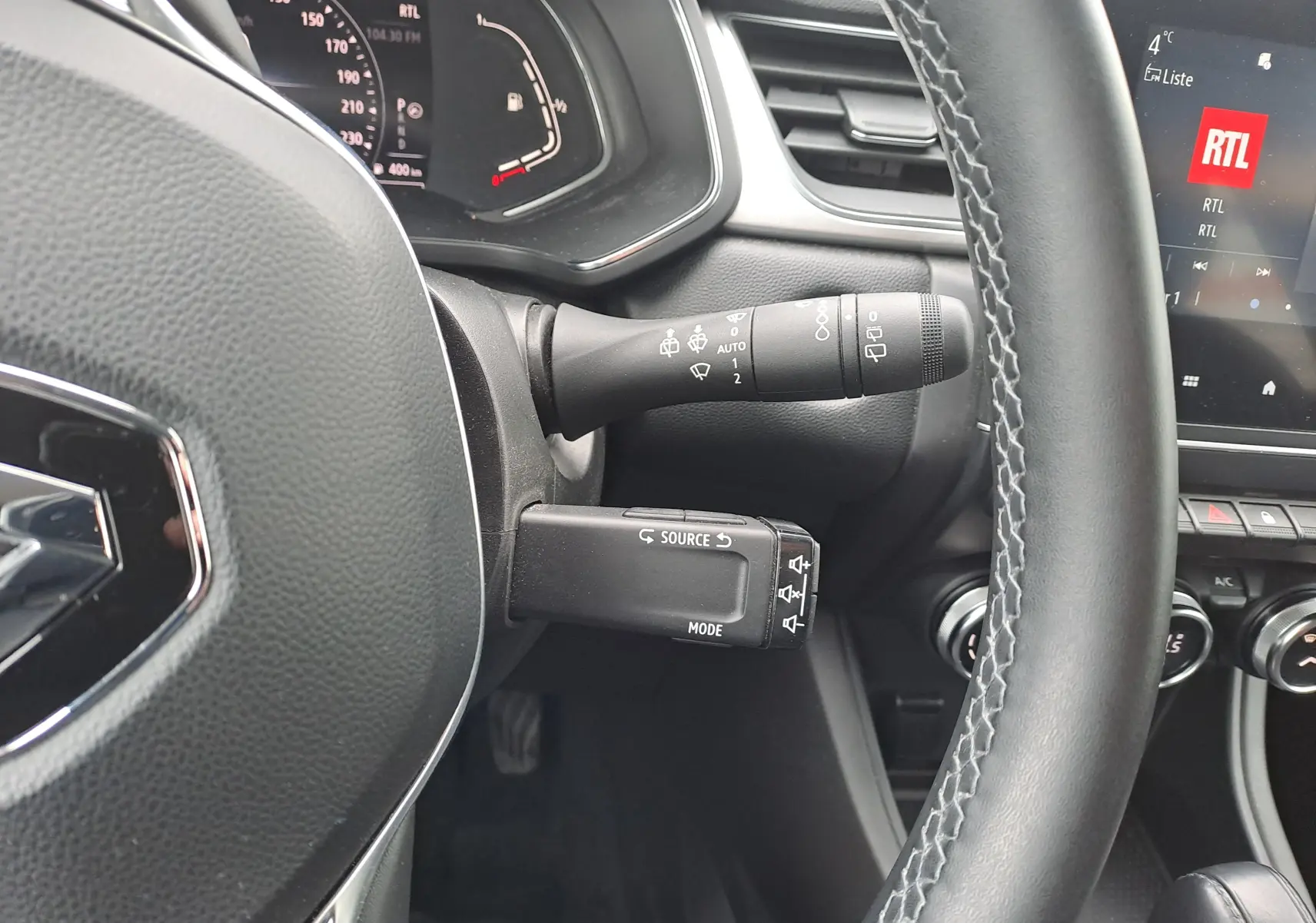 Vue rapprochée du volant et des commandes à gauche du tableau de bord du Renault Captur bleu marine 2022.