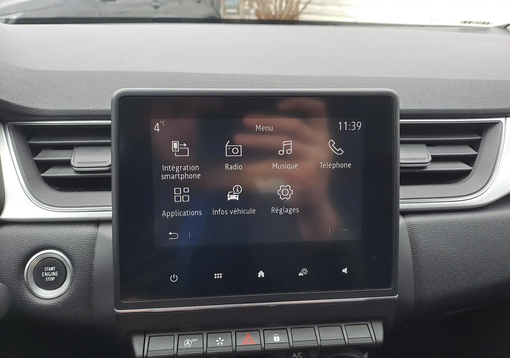 Écran tactile central du tableau de bord du Renault Captur 2022, avec commandes multimédia et bouton start/stop visible.