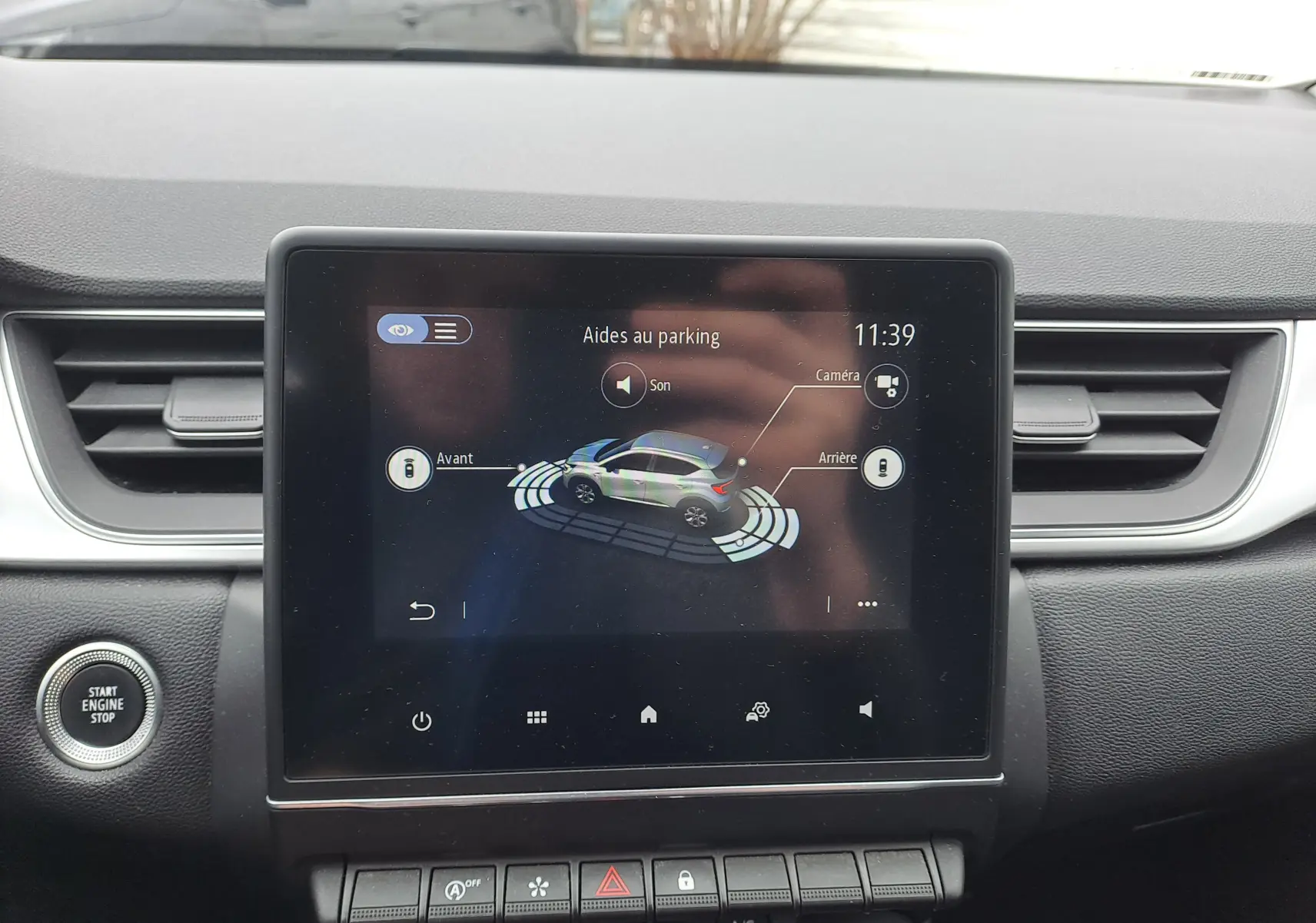 Écran tactile central du Renault Captur 2022 montrant l'aide au parking avec vue 3D du véhicule bleu marine.