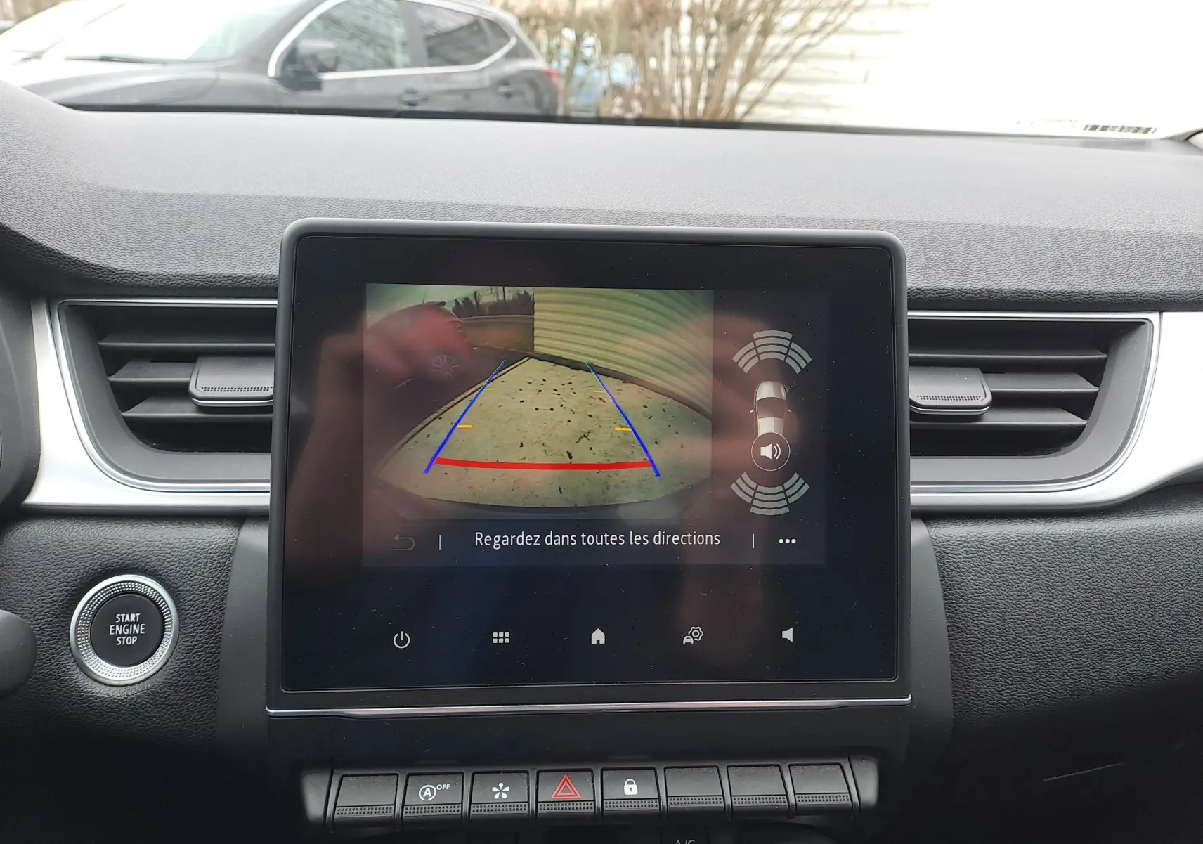 Écran central du Renault Captur 2022 montrant la caméra de recul avec lignes de guidage colorées, intérieur noir.