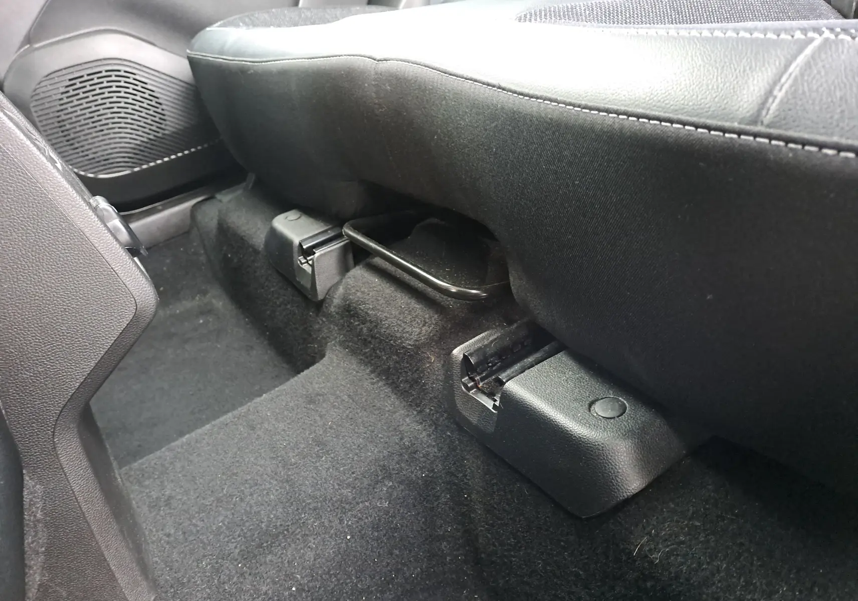 Gros plan sous le siège arrière côté droit du Renault Captur 1.3 TCE 140 Intens 2022, intérieur noir.