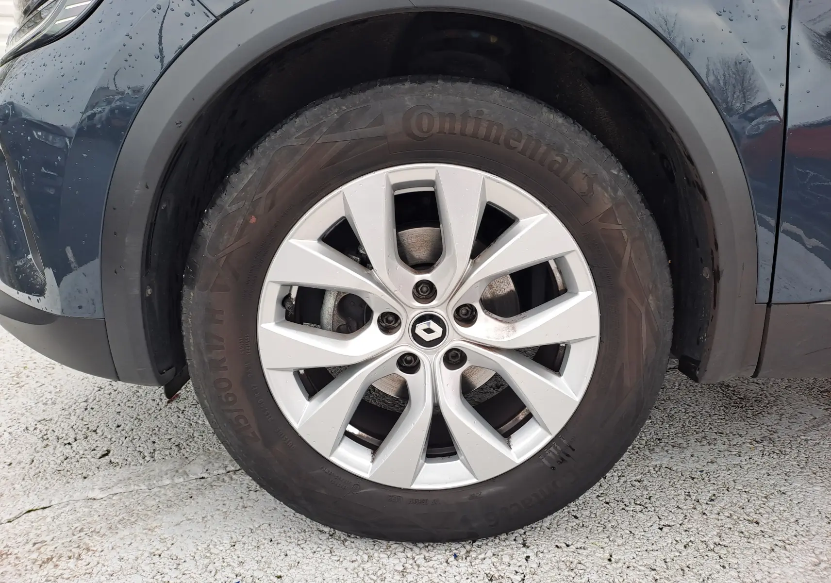 Gros plan sur la roue avant gauche du Renault Captur bleu marine 2022 avec jante alliage et pneu Continental.