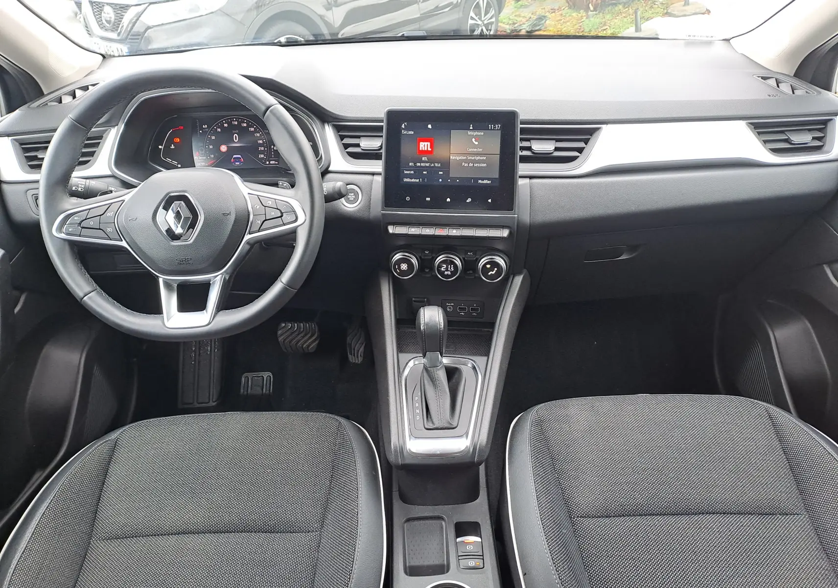 Vue intérieure avant du Renault Captur 1.3 TCE 140 Intens 2022, tableau de bord noir avec écran tactile central et volant multifonction.