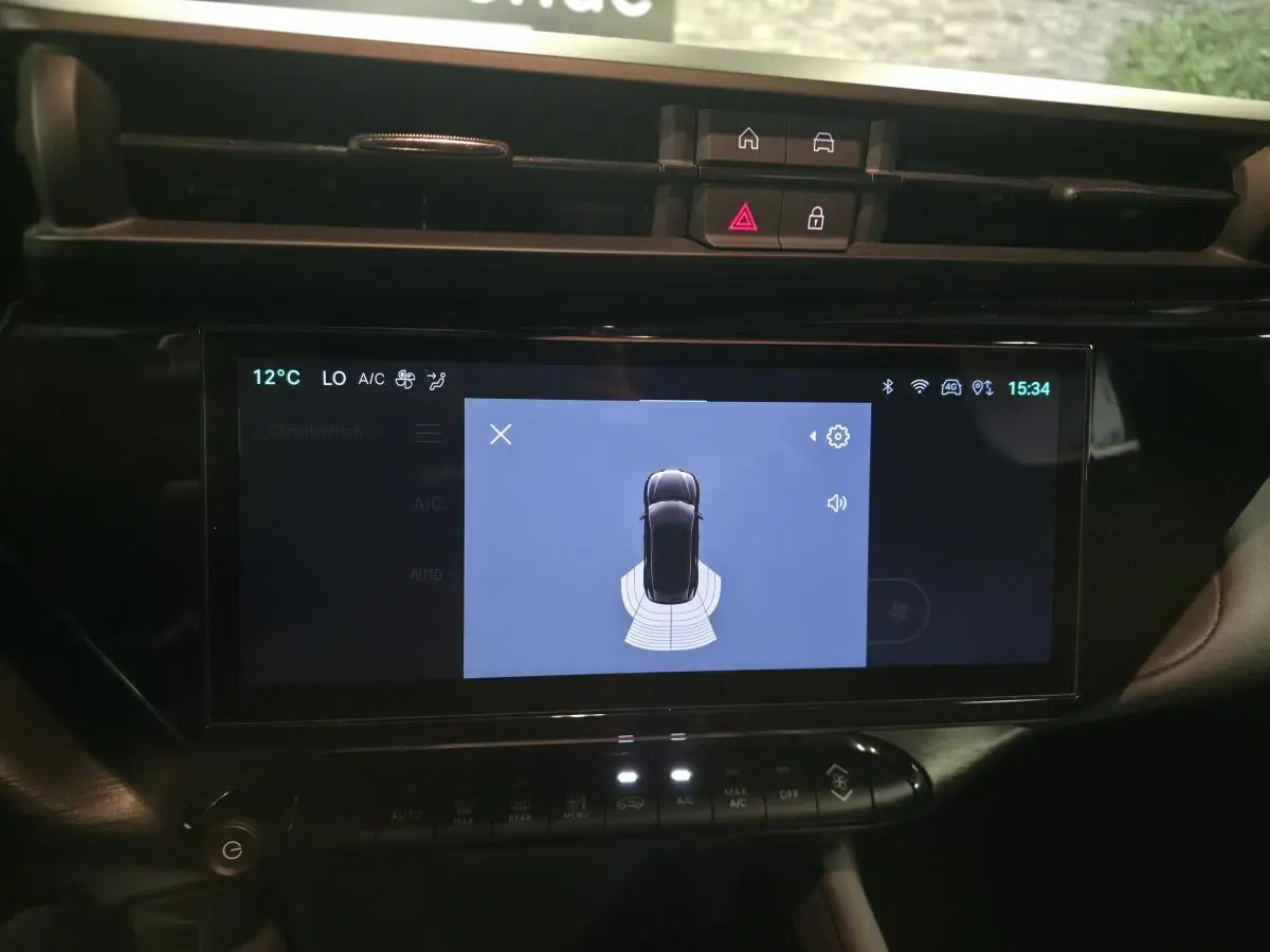 Écran tactile central affichant l’aide au stationnement de l’Alfa Romeo Junior 1.2 Ibrida gris, vue intérieure du tableau de bord.