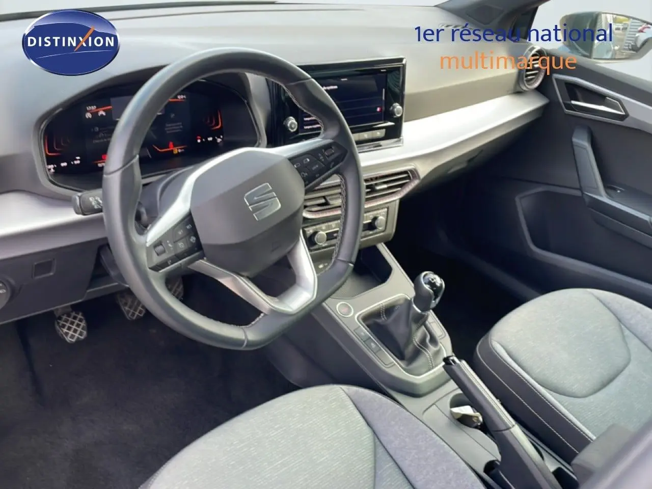 Vue intérieure du poste de conduite de la SEAT IBIZA 2025, volant cuir noir et levier de vitesse manuel visible.