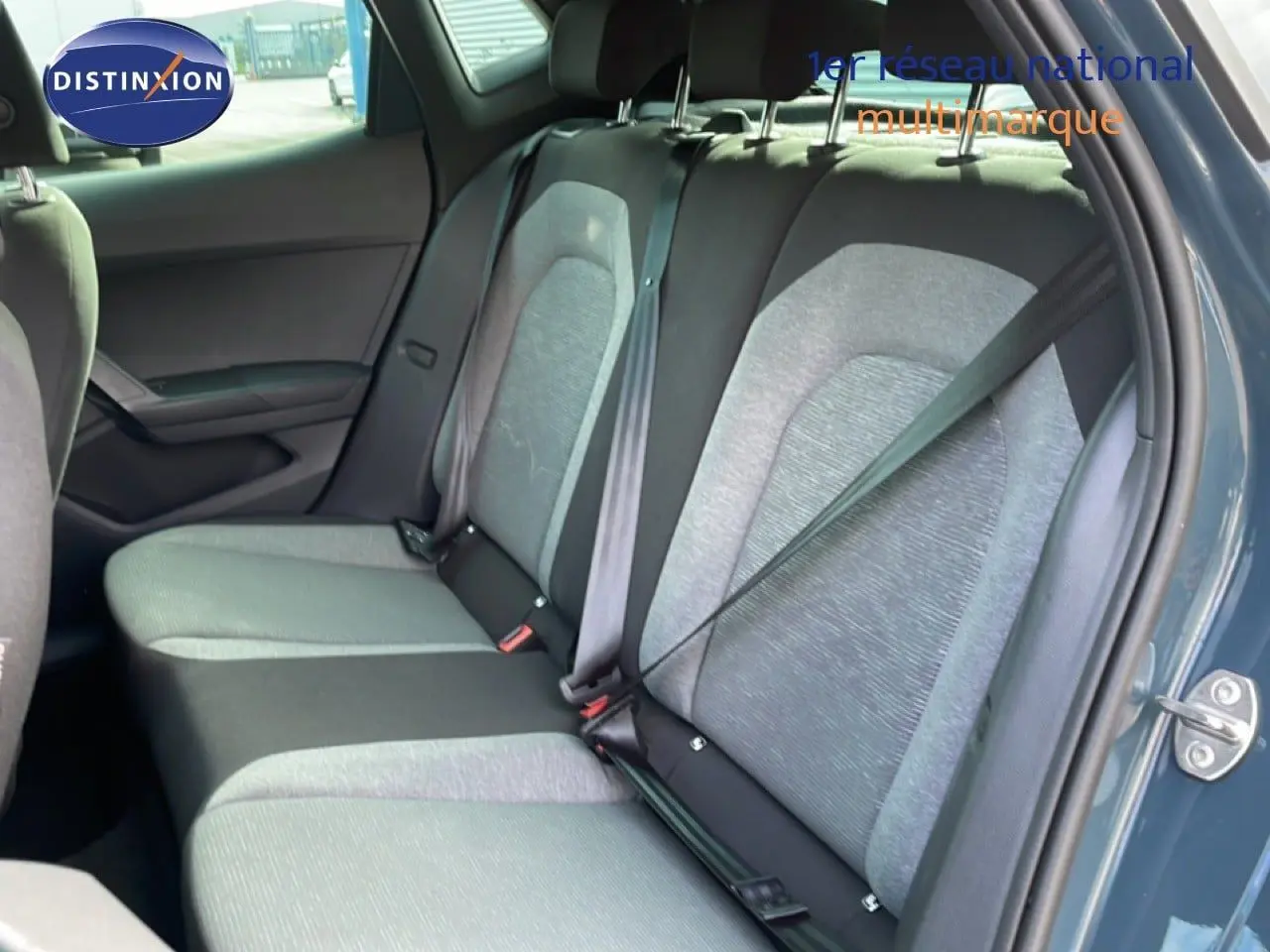Vue intérieure côté droit des sièges arrière gris clair et foncé d'une SEAT Ibiza bleu fjord 2025, porte ouverte.