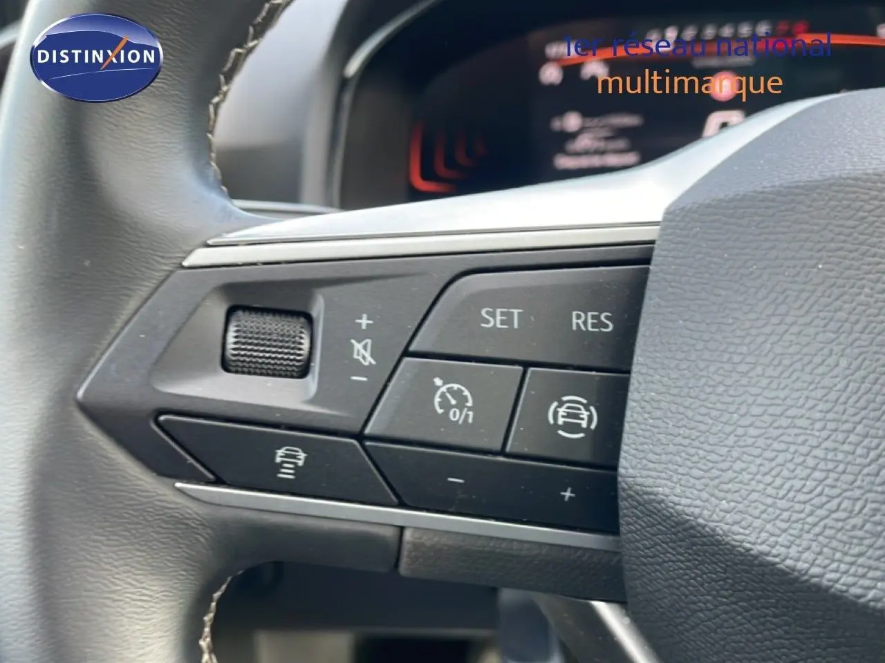 Gros plan sur les commandes de régulateur de vitesse au volant d’une SEAT Ibiza bleu Fjord 2025.
