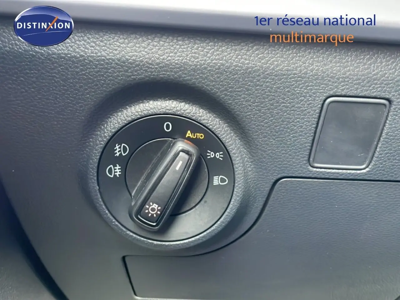 Gros plan sur le bouton de commande des phares dans l’habitacle d’une SEAT Ibiza bleu Fjord 2025.