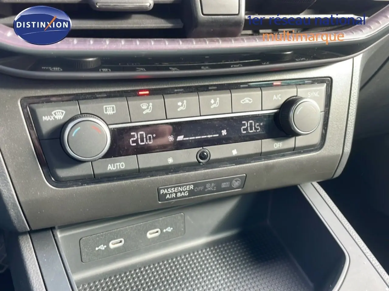 Détail de la console centrale avec la climatisation automatique affichant 20°C, boutons et ports USB visibles, intérieur noir.