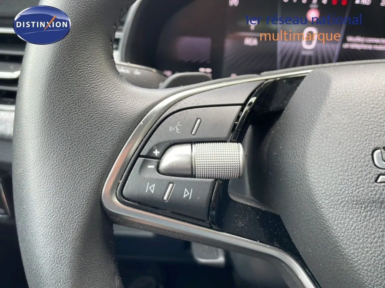 Gros plan sur les commandes gauche du volant d’une Skoda Scala 2025, finition noire avec molette texturée.