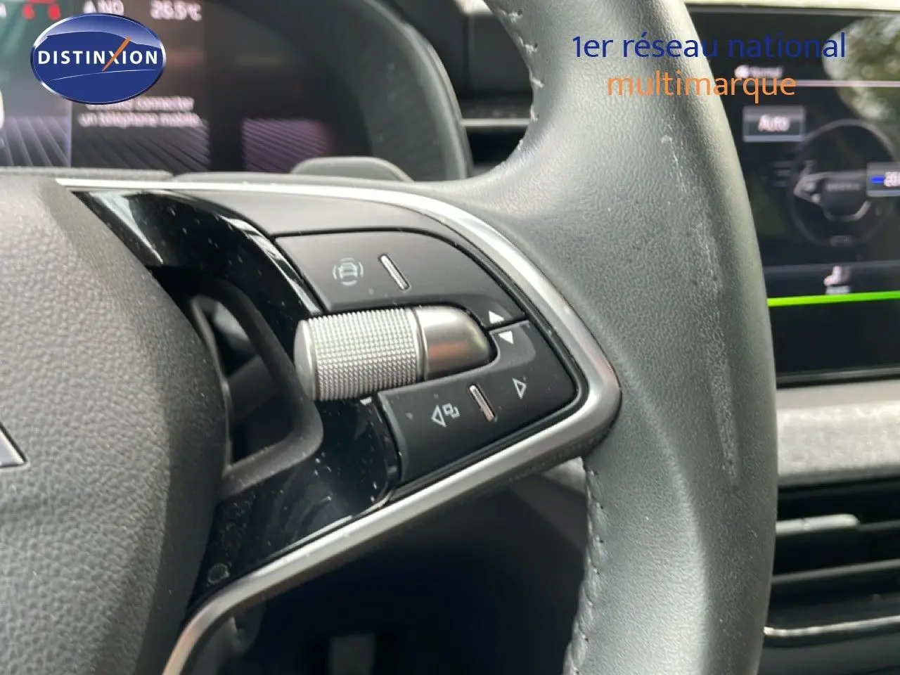 Gros plan sur les commandes du volant cuir noir de la Skoda Scala 2025, avec molette et boutons multifonctions.