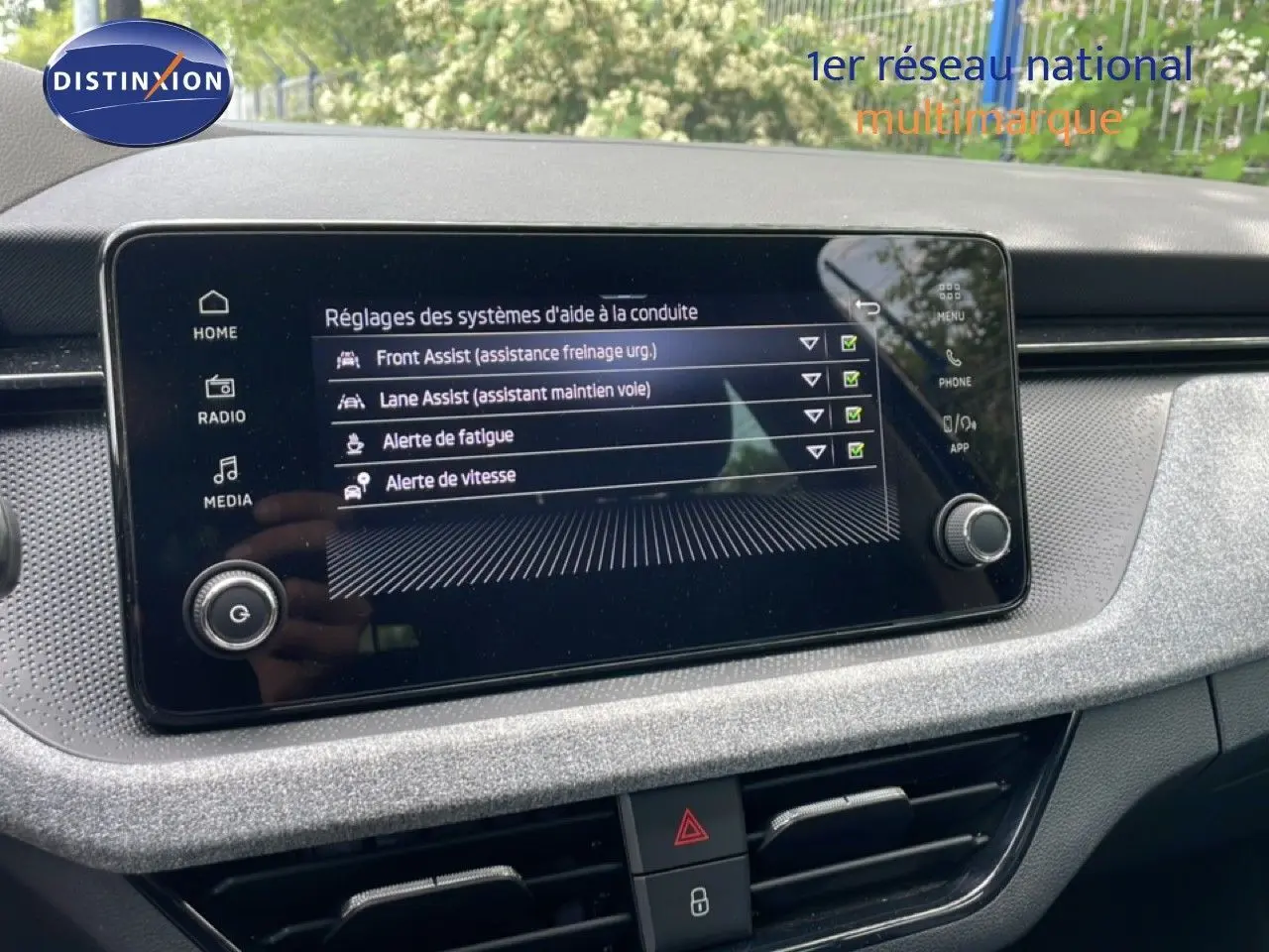 Écran tactile central de la Skoda Scala 2025 affichant les réglages des aides à la conduite dans un intérieur gris noir.