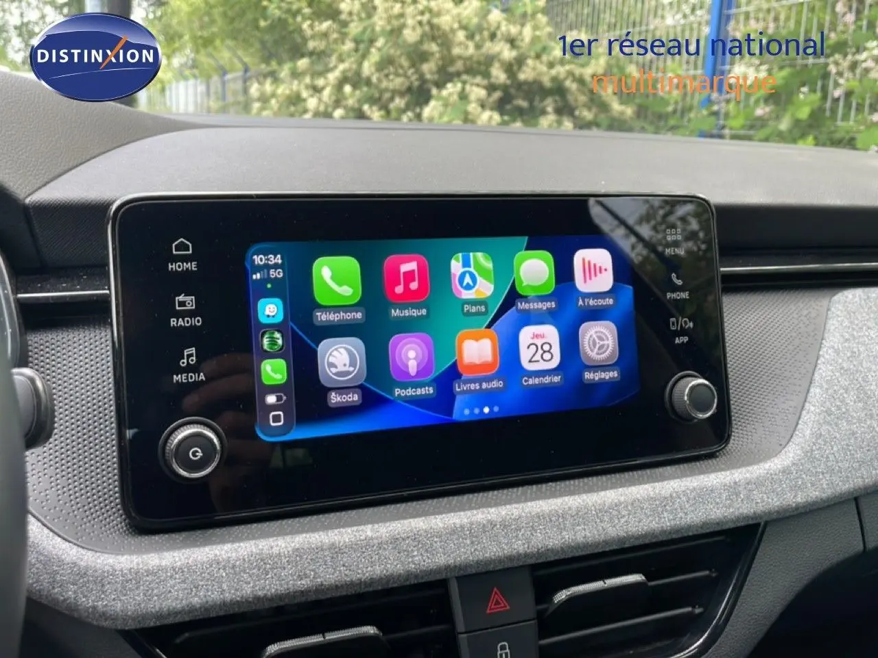 Écran tactile central de la Skoda Scala 2025 affichant l’interface Apple CarPlay dans un intérieur gris noir.