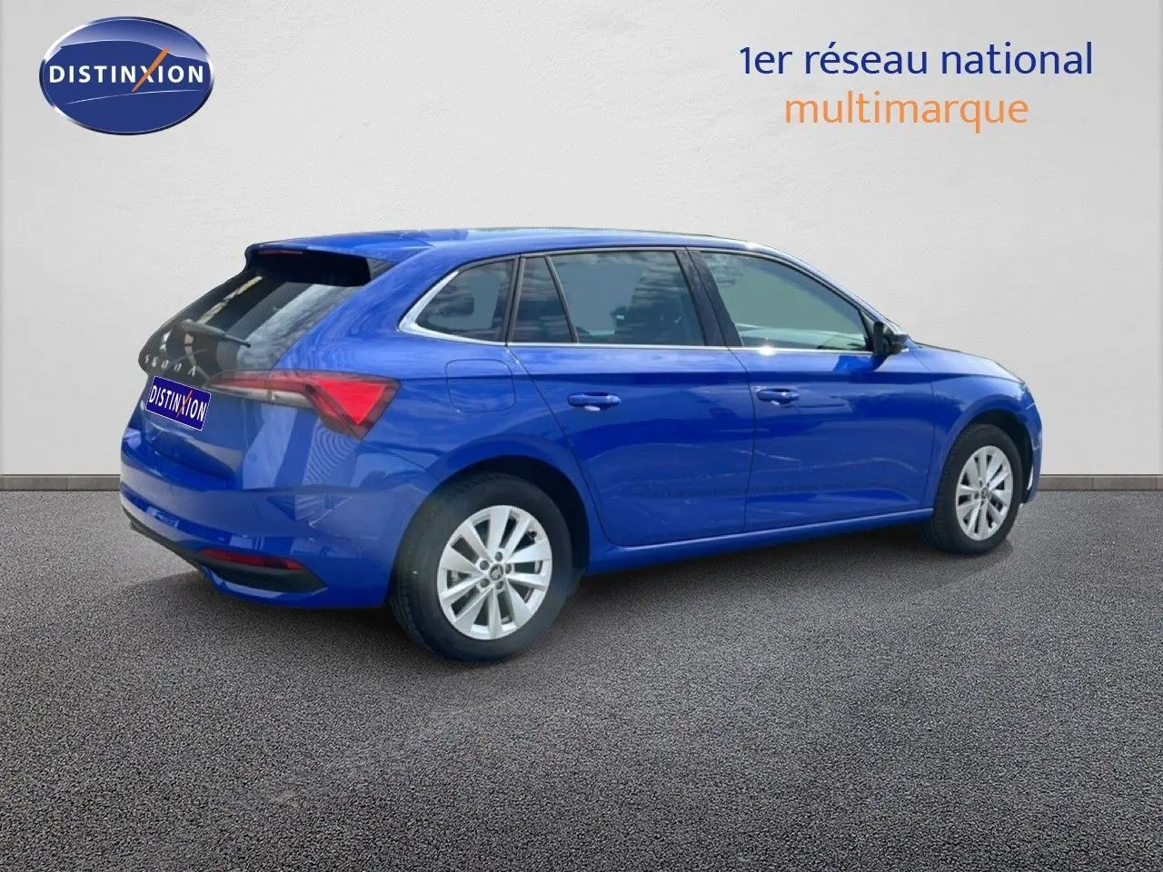 Vue 3/4 arrière droite d'une Skoda Scala 2025 en bleu racing metal avec jantes alliage et feux arrière LED.