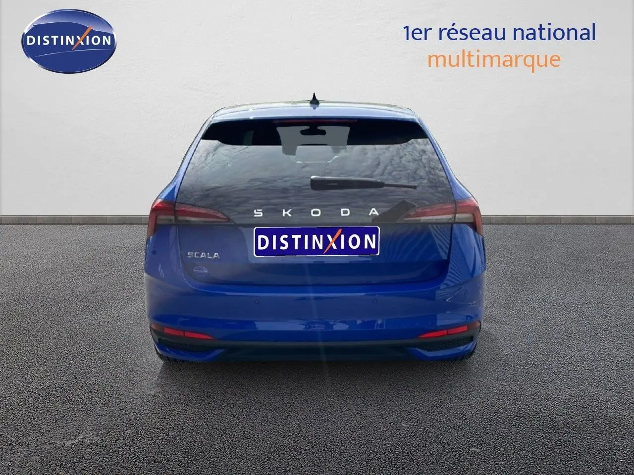 Vue arrière d'une Skoda Scala 2025 en bleu racing metal, avec feux arrière étirés et logo distinctif au centre.