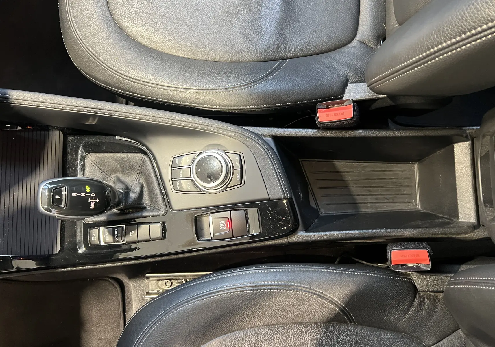 Vue plongeante sur la console centrale noire du BMW X1 F48 2017 avec levier de vitesse et commandes intégrées.