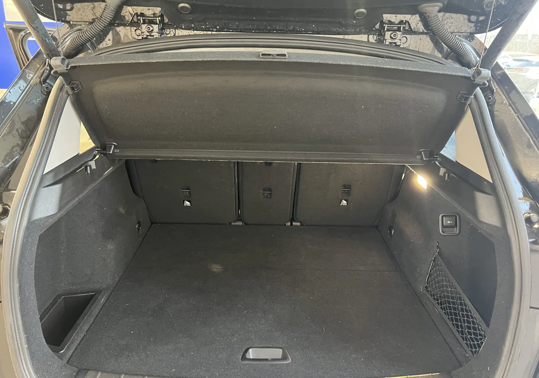 Coffre ouvert d'un BMW X1 F48 Saphirschwarz 2017, montrant un espace de chargement propre et bien éclairé.