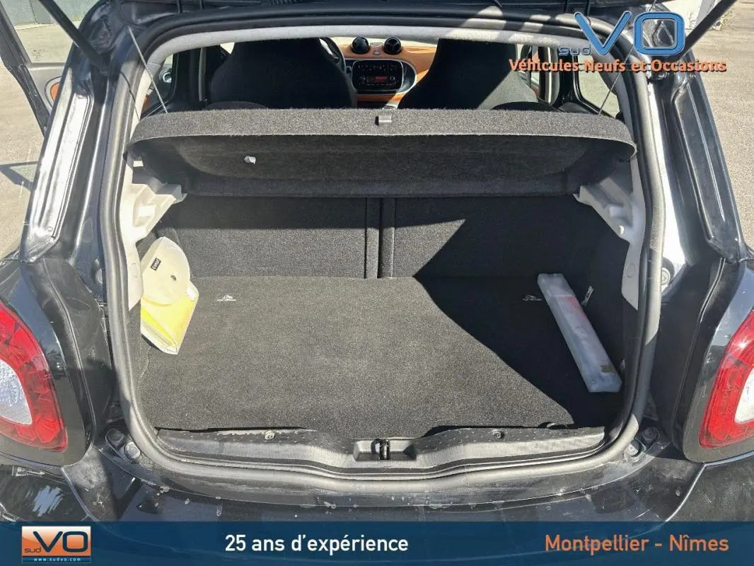 Coffre ouvert d'une Smart Forfour noire de 2015, vue arrière montrant l'espace de chargement et l'intérieur du véhicule.