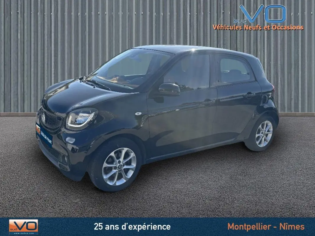 Vue 3/4 avant droite d'une Smart Forfour noire de 2015 avec jantes alliage et vitres teintées.