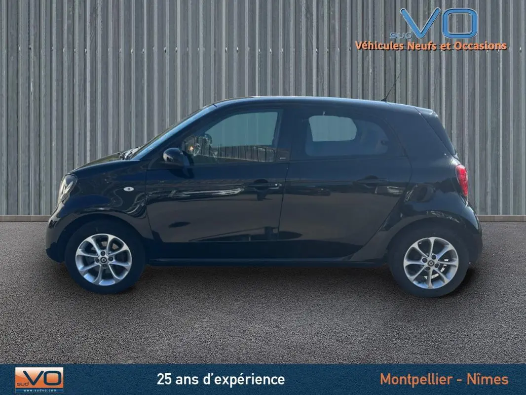 Profil côté gauche d'une Smart Forfour noire de 2015, compacte et urbaine, avec jantes alliage visibles.