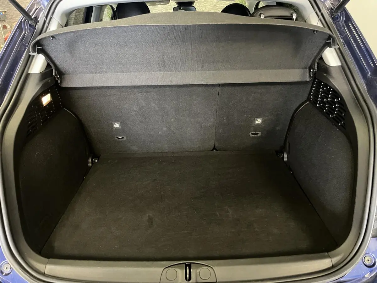 Coffre ouvert vu de l'arrière d'une Fiat 500X bleu, montrant l'espace de chargement et la plage arrière.