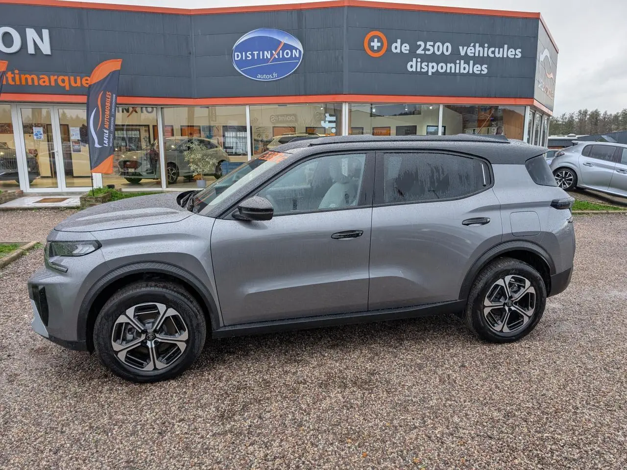 Vue de profil côté gauche d'un Citroën C3 Aircross gris métallisé avec toit noir et jantes alliage 17 pouces diamantées.