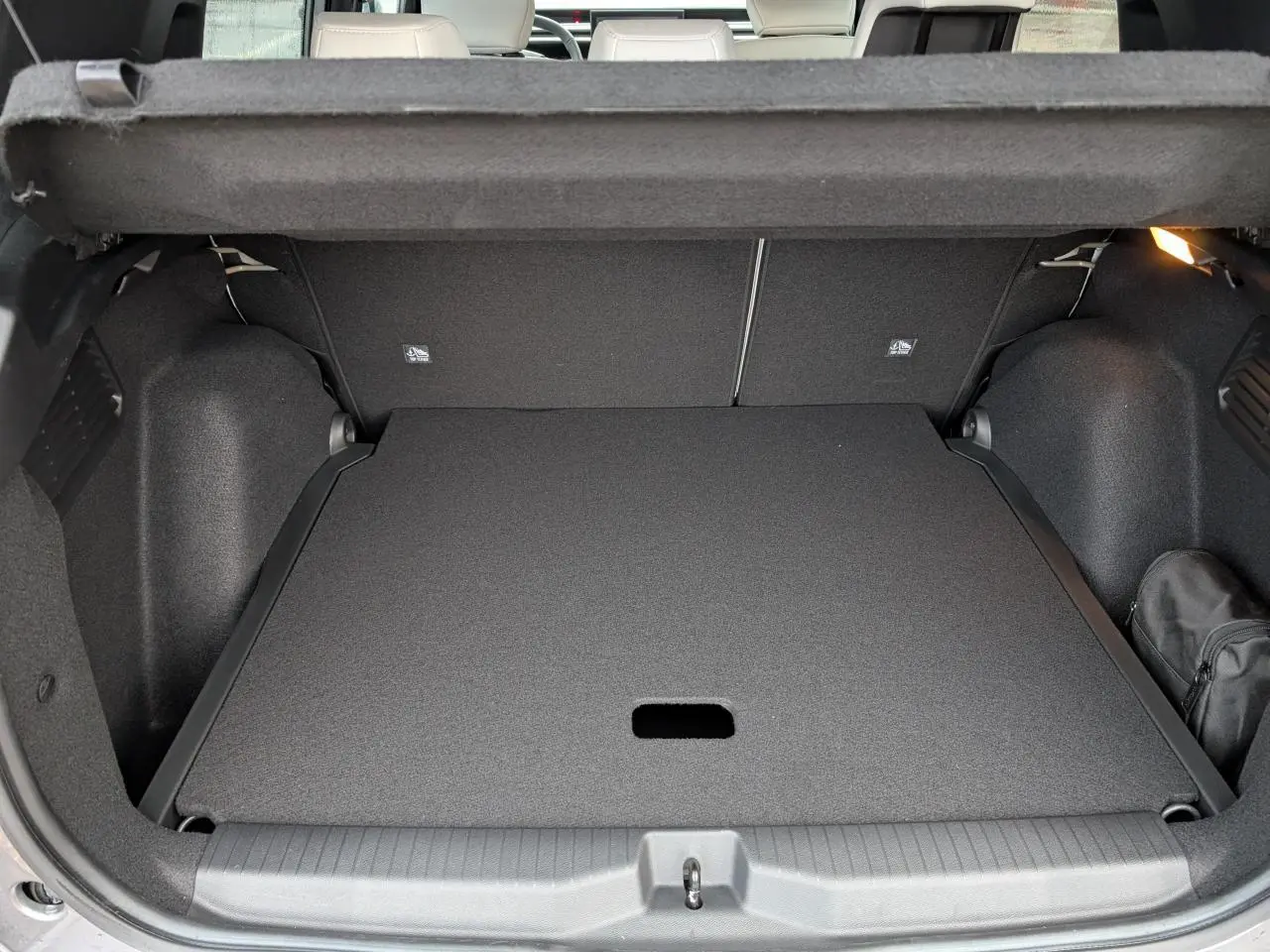 Coffre ouvert vu de l'arrière du Citroën C3 Aircross 2025 gris métallisé avec cache-bagages en place.