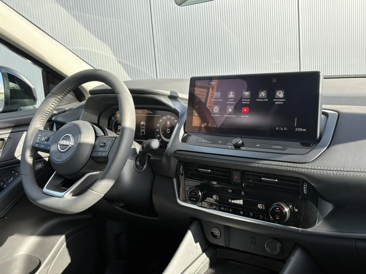 Vue intérieure côté conducteur du tableau de bord noir du Nissan Qashqai 2025 avec écran tactile et volant multifonction.
