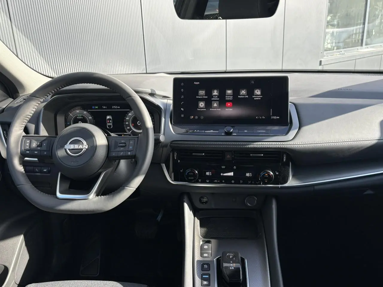 Vue intérieure frontale du tableau de bord noir du Nissan Qashqai III e-Power avec écran tactile et volant multifonction.