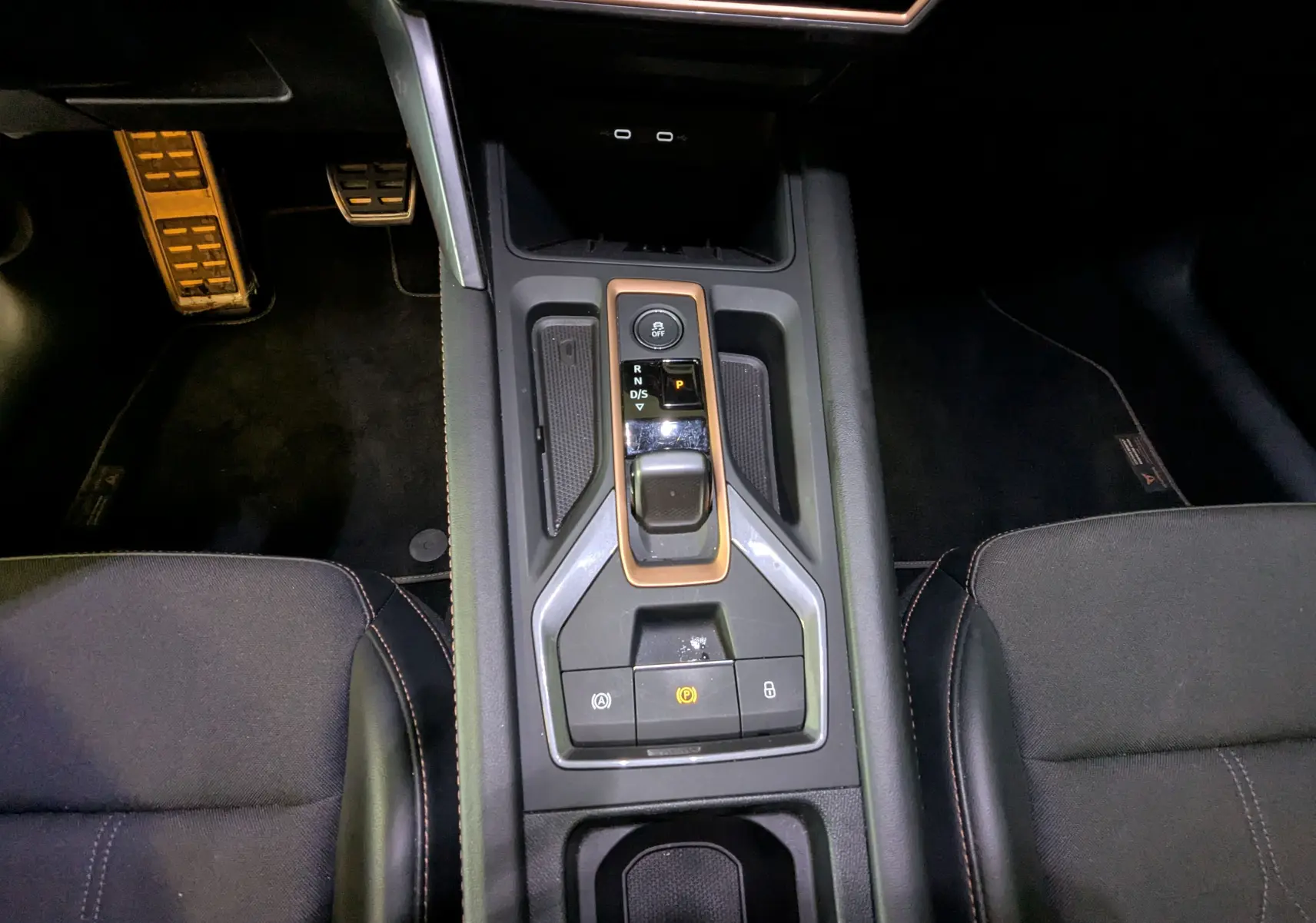 Vue intérieure centrée sur la console centrale noire avec levier de vitesses et boutons de commande du CUPRA Leon ST gris Magnetic.