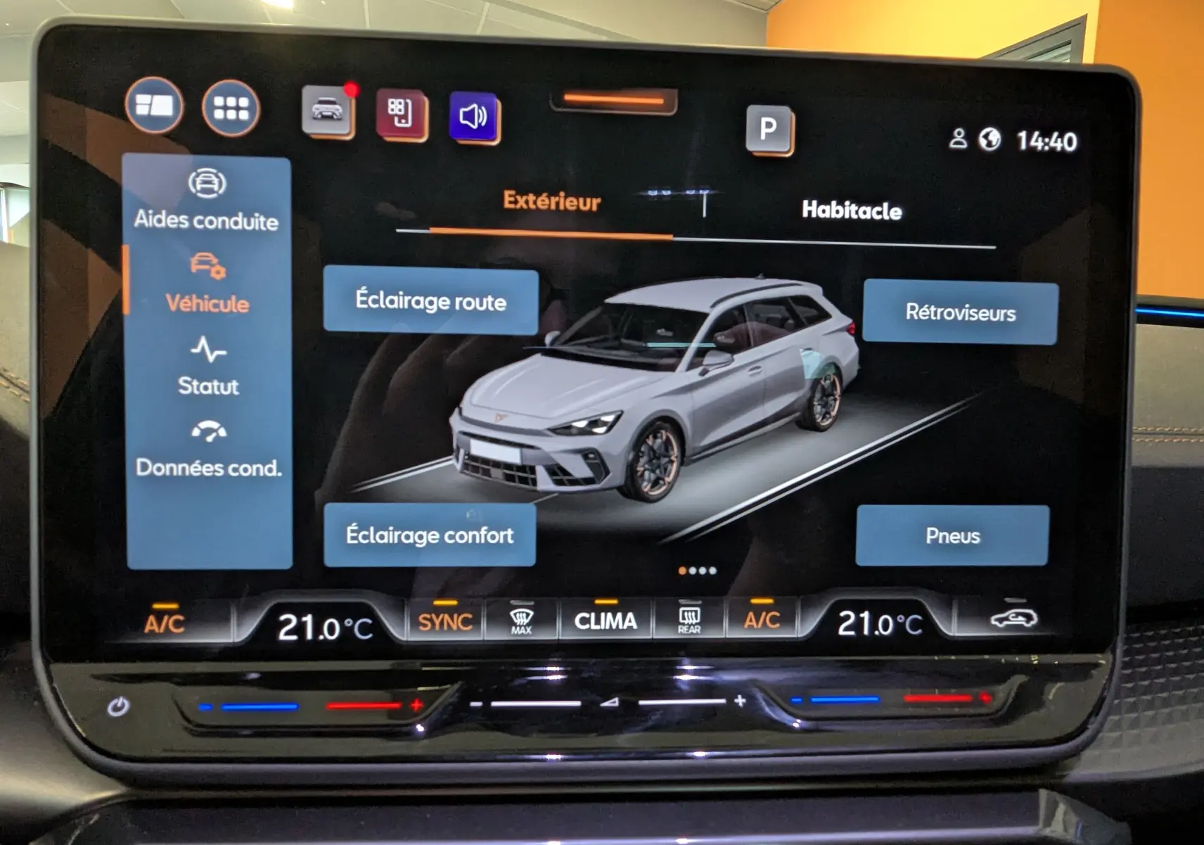 Écran tactile intérieur affichant la configuration d’éclairage d’une CUPRA LEON ST gris magnetic en vue 3/4 avant virtuelle.