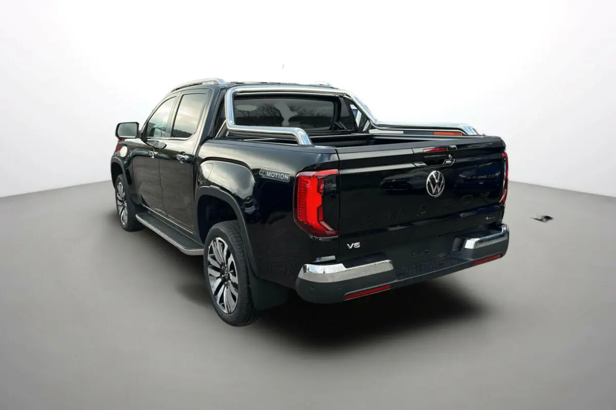 Vue 3/4 arrière droite du pick-up Volkswagen Amarok V6 noir avec arceaux inox et jantes alu 21 pouces.