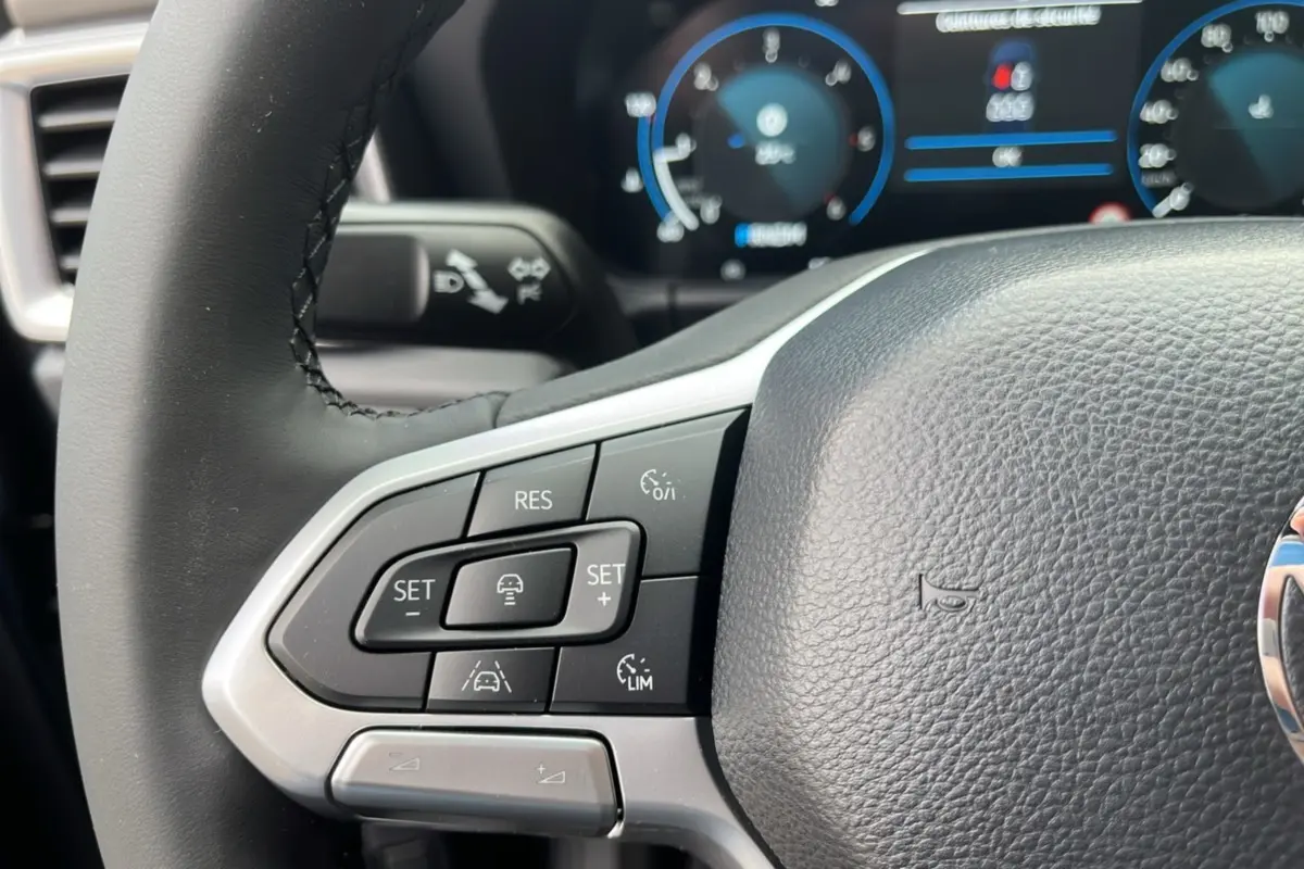 Gros plan sur le volant cuir noir du Volkswagen Amarok V6 240 BVA10 Aventura avec commandes multifonctions.