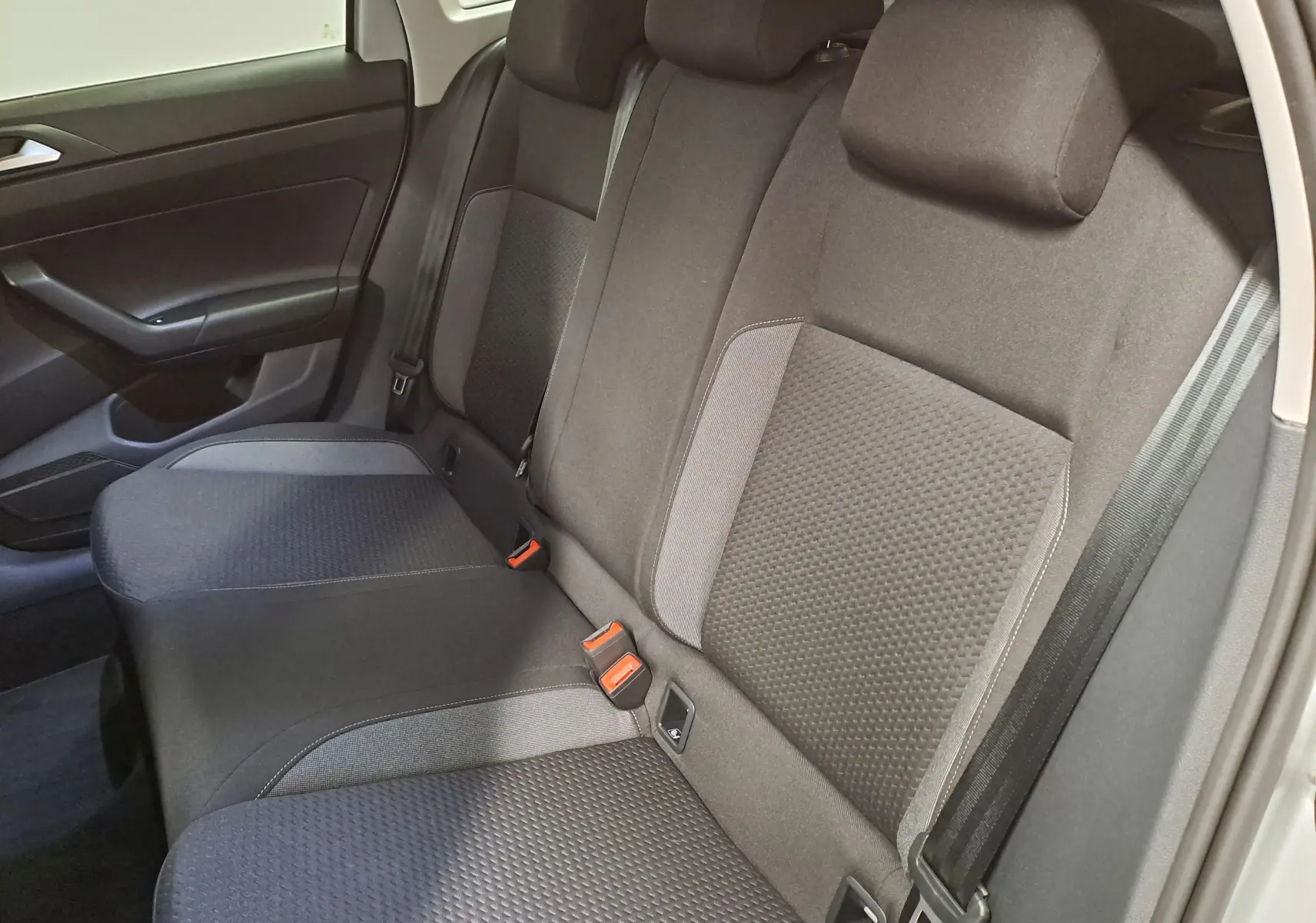 Vue intérieure des sièges arrière noirs et gris du Volkswagen Taigo 2025, côté droit avec ceinture de sécurité visible.