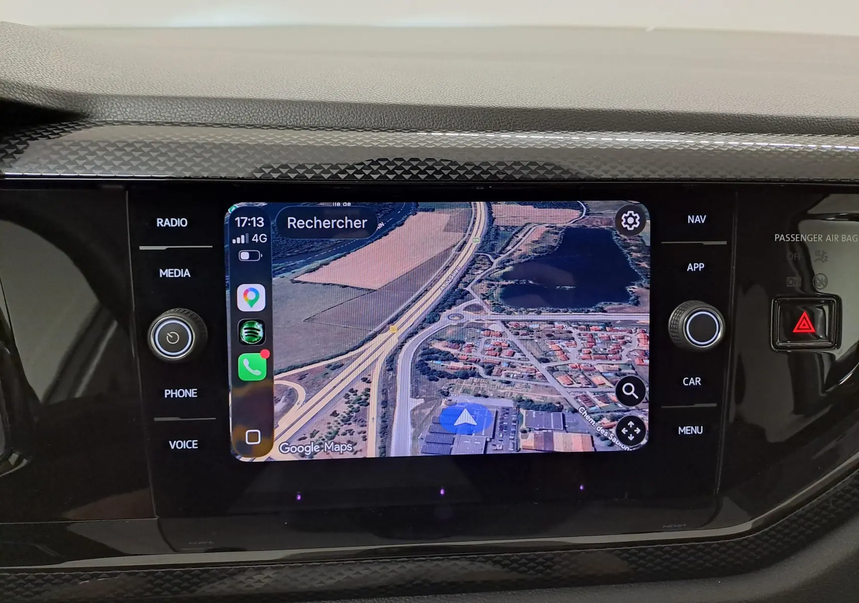 Écran tactile central du Volkswagen Taigo 2025 affichant une carte satellite avec commandes autour, intérieur noir.