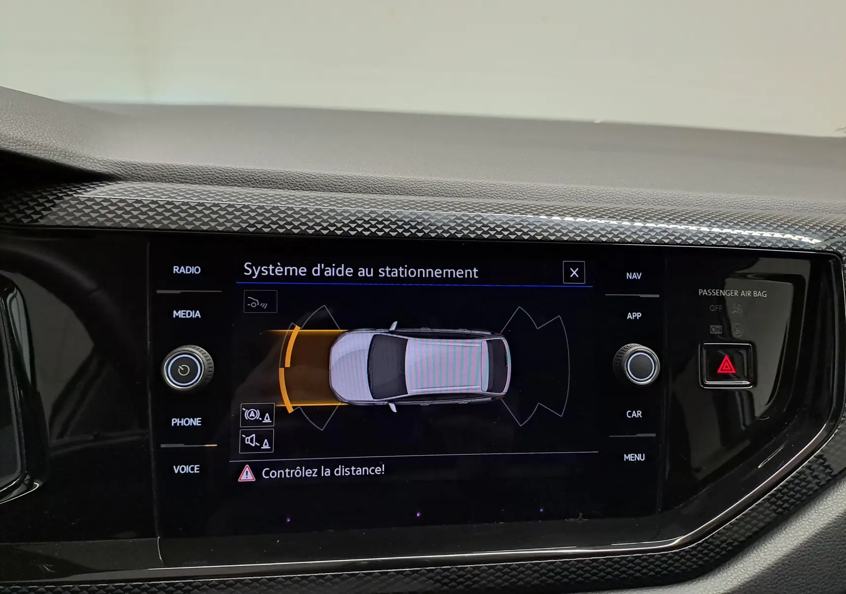 Écran tactile intérieur montrant le système d'aide au stationnement du Volkswagen Taigo 2025 en vue de dessus du véhicule.