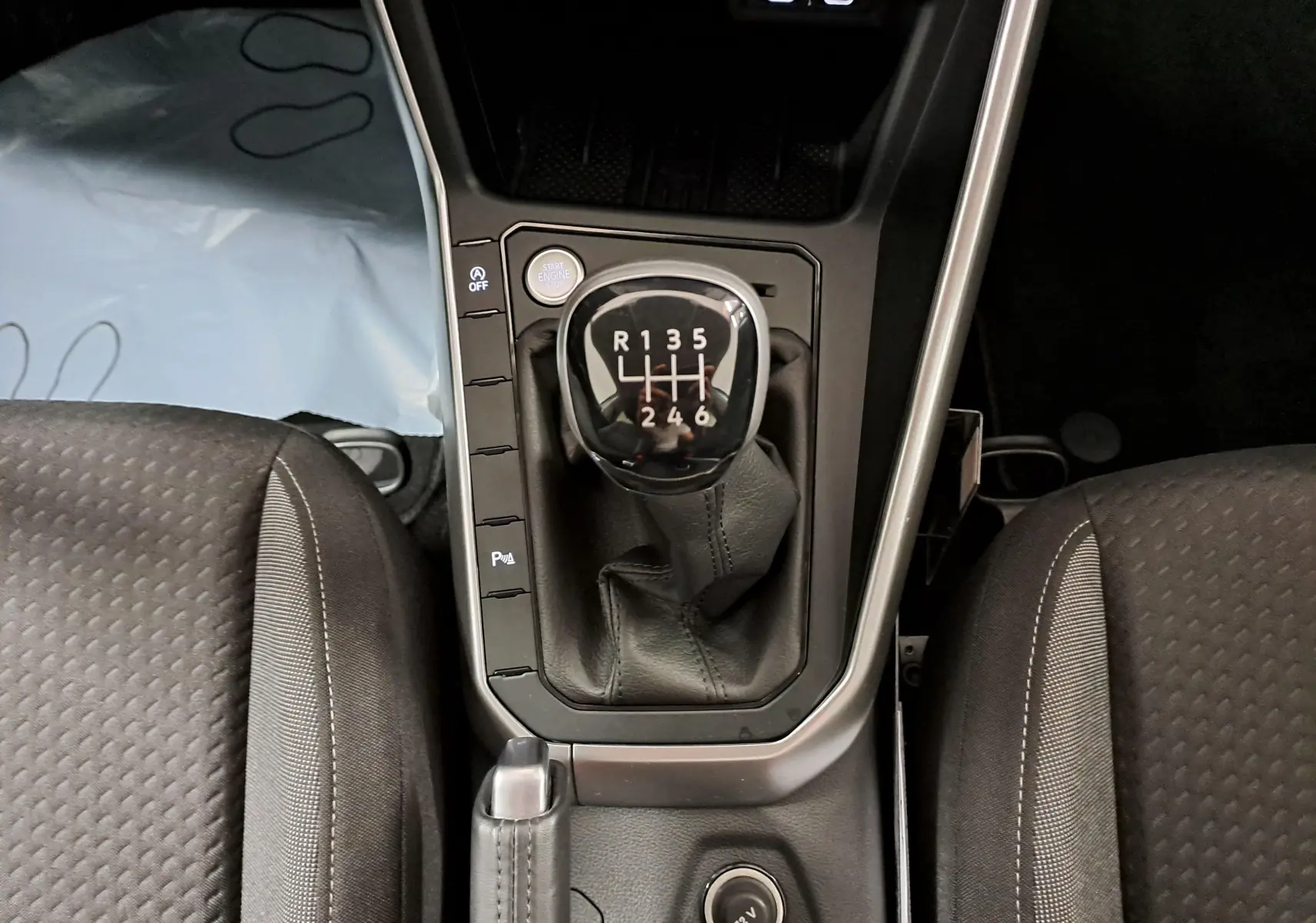 Vue plongeante sur le levier de vitesses manuel du Volkswagen Taigo 2025, intérieur noir avec coutures grises.