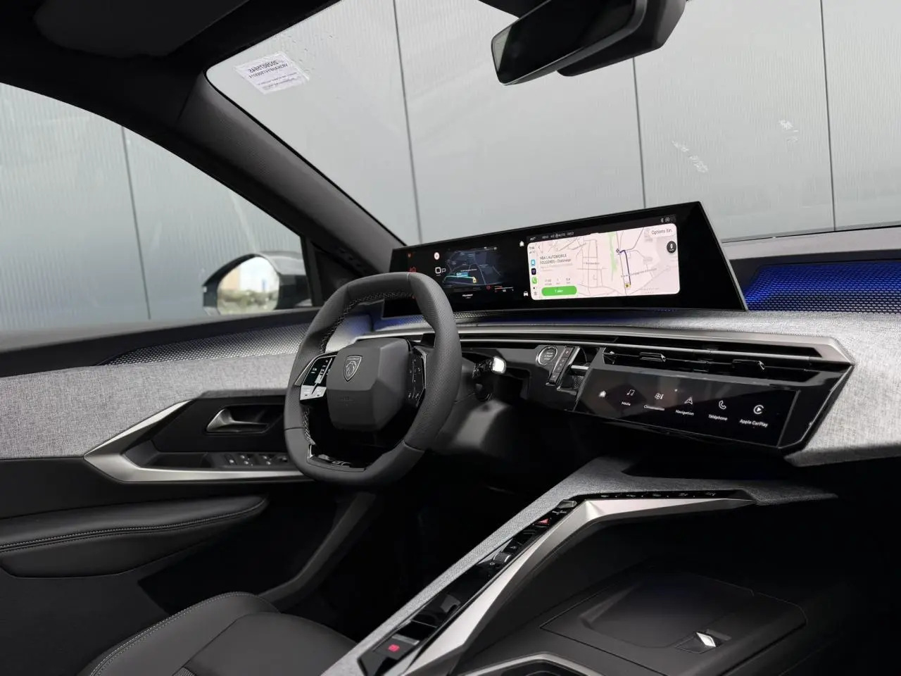Intérieur Peugeot 3008 Hybrid 145 GT vu côté conducteur, tableau de bord numérique panoramique et volant compact noir.