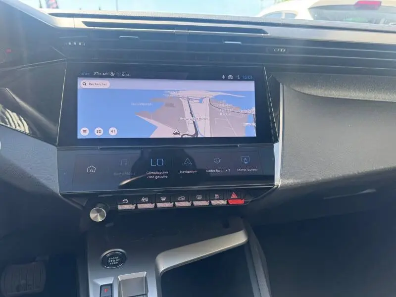 Vue rapprochée du tableau de bord de la Peugeot 308 Hybrid 145 e-DCS6 Allure 2025 avec écran tactile de navigation et commandes tactiles.