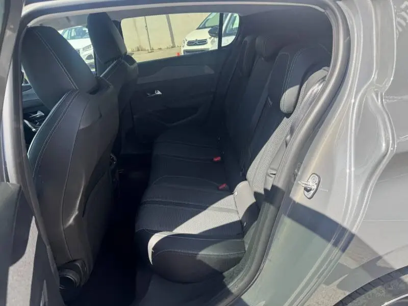 Vue intérieure côté droit des sièges arrière noirs d'une Peugeot 308 gris 2025, montrant l'espace et les finitions.