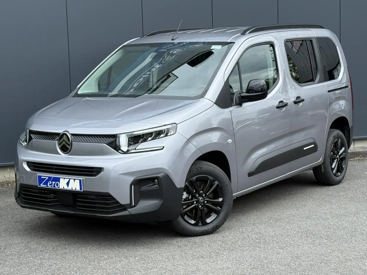 Citroën Berlingo Multispace gris acier en 3/4 avant droit avec jantes noires et lunette arrière ouvrante.