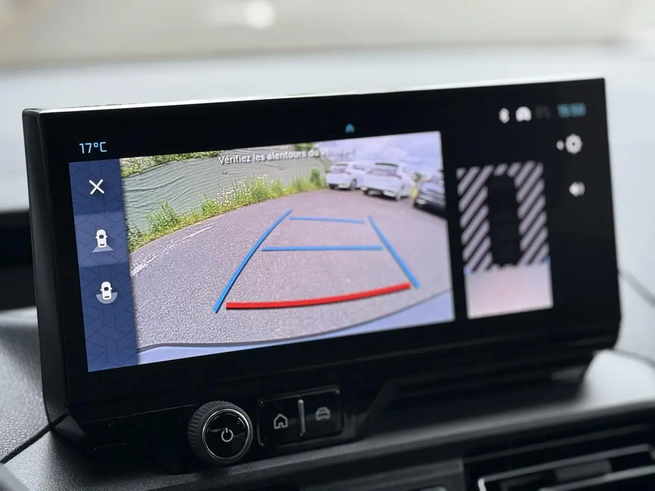 Écran tactile intérieur montrant la caméra de recul avec guidage coloré dans un Citroën Berlingo gris acier.