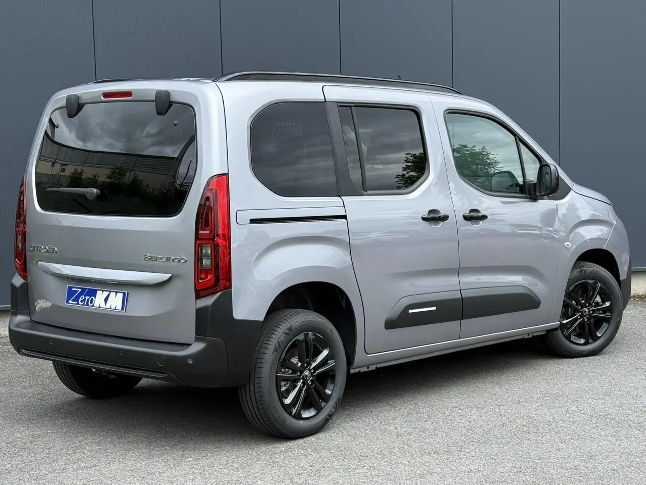 Vue 3/4 arrière droite du Citroën Berlingo Multispace gris acier avec jantes noires et lunette arrière ouvrante.