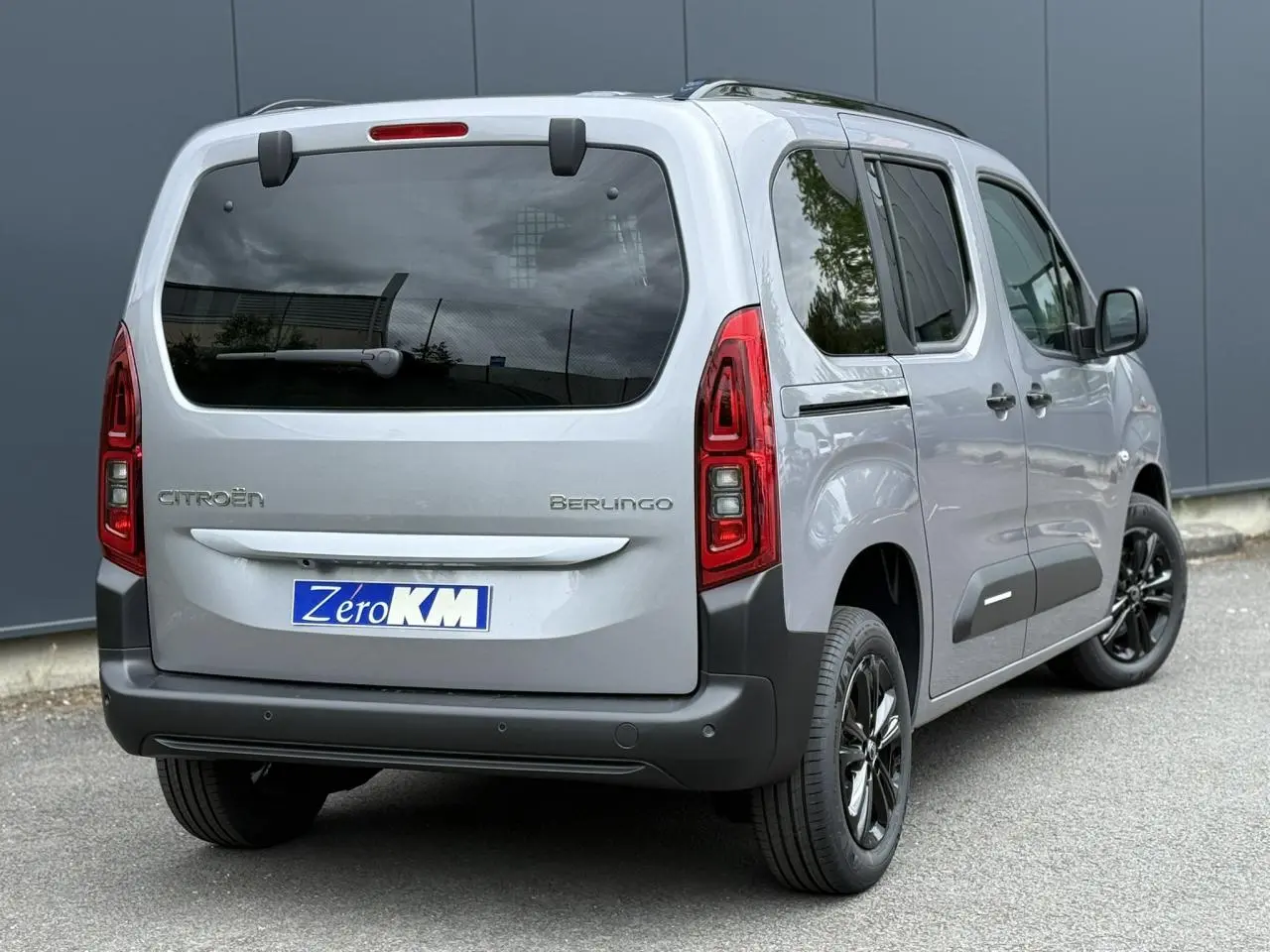 Vue 3/4 arrière droite du Citroën Berlingo gris acier avec lunette arrière ouvrante et jantes alliage noires.